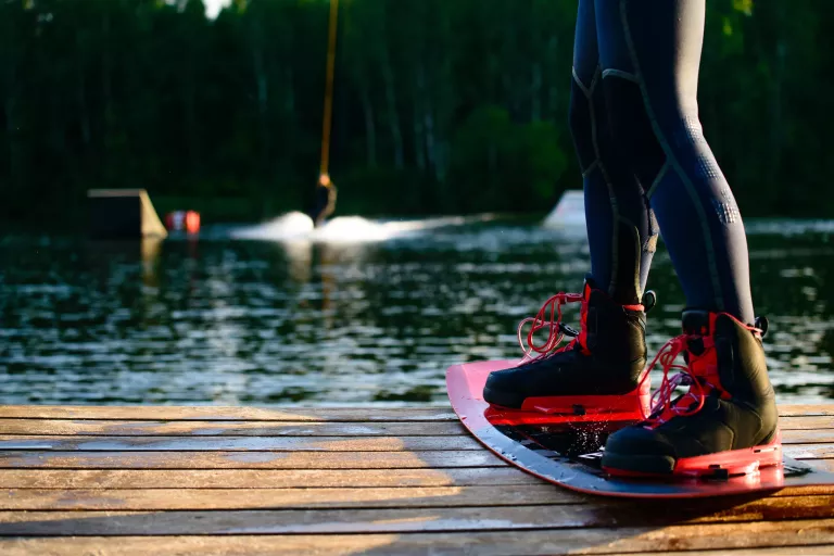 men’s feet on a wakeboard On the lake